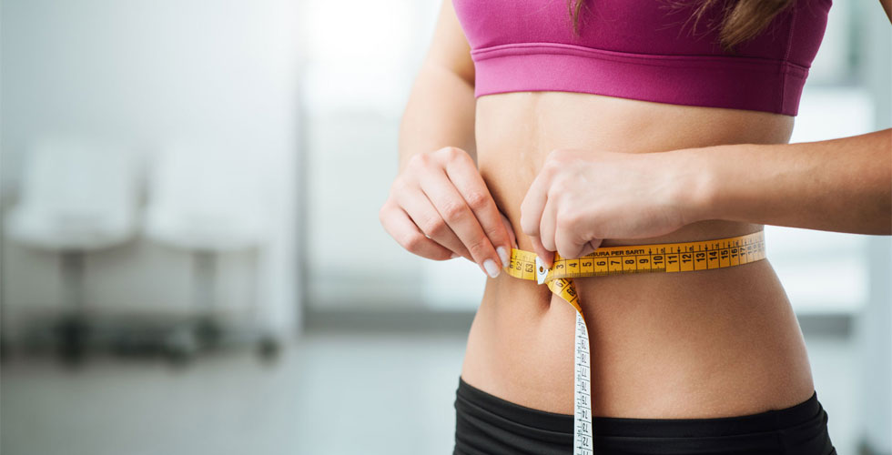 healthy woman measuring waist